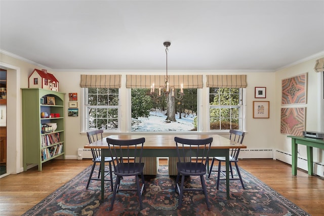 dining room with an inviting chandelier, ornamental molding, and wood-type flooring