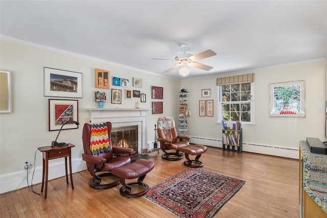 sitting room with ornamental molding, a brick fireplace, baseboard heating, and light hardwood / wood-style flooring