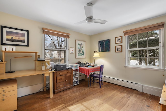 office featuring ceiling fan, wood-type flooring, plenty of natural light, and baseboard heating