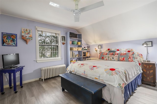 bedroom featuring hardwood / wood-style flooring, lofted ceiling, radiator, and ceiling fan