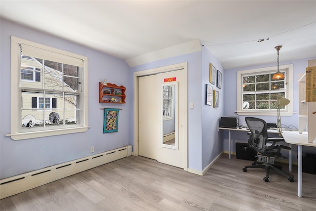 office space with baseboard heating, light wood-type flooring, and a wealth of natural light