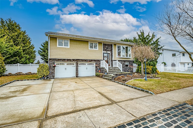 split foyer home featuring a front lawn and a garage