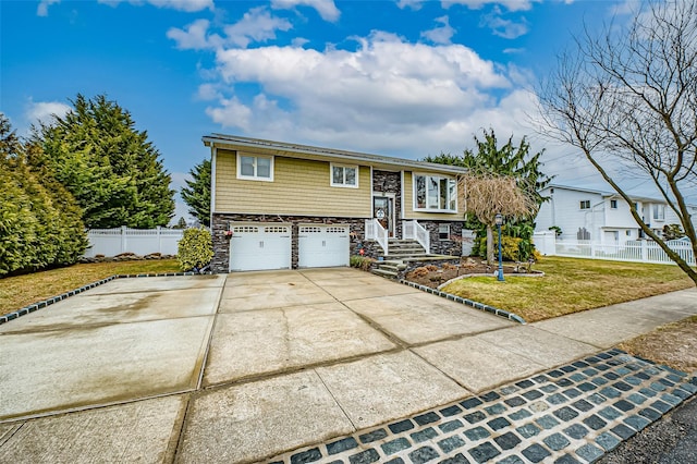 raised ranch featuring a front lawn and a garage