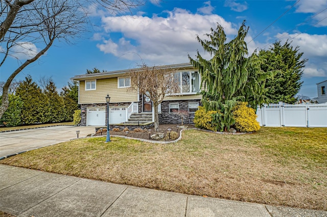 split foyer home featuring a front lawn and a garage