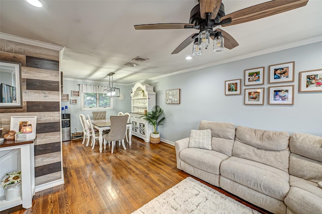 living room featuring ceiling fan, ornamental molding, and hardwood / wood-style flooring