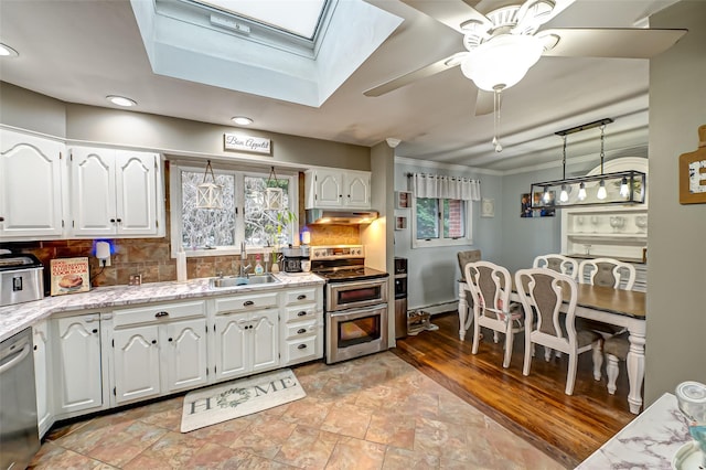 kitchen featuring backsplash, appliances with stainless steel finishes, sink, and white cabinetry