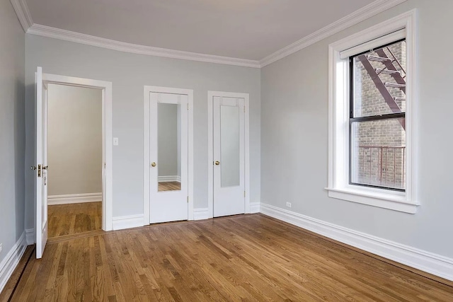 unfurnished bedroom with wood-type flooring and ornamental molding