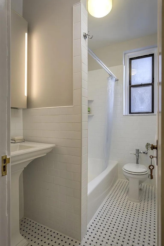 bathroom with tile walls, tile patterned floors, toilet, and shower / bathtub combination with curtain