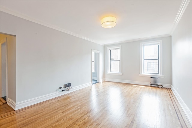 unfurnished room with crown molding, radiator, and light wood-type flooring