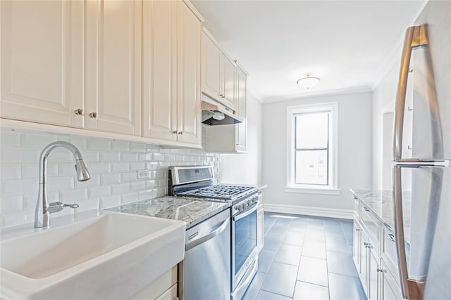 kitchen with sink, decorative backsplash, stainless steel appliances, crown molding, and light stone countertops