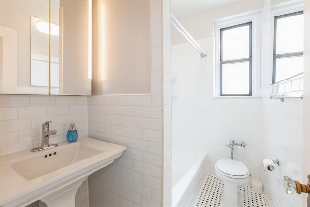 full bathroom with toilet, sink, tile walls, tiled shower / bath combo, and tile patterned flooring