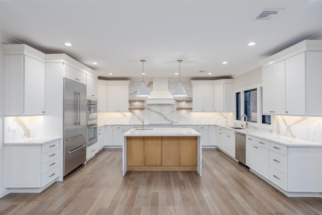 kitchen featuring white cabinetry, a center island, pendant lighting, and appliances with stainless steel finishes