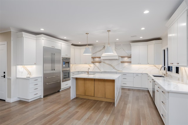 kitchen with white cabinets, a kitchen island with sink, pendant lighting, and sink