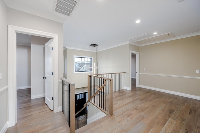 hall with light hardwood / wood-style flooring and ornamental molding