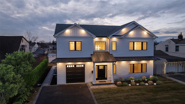 modern farmhouse featuring a garage and a lawn