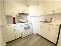 kitchen featuring light wood-type flooring, sink, white gas stove, and white cabinets