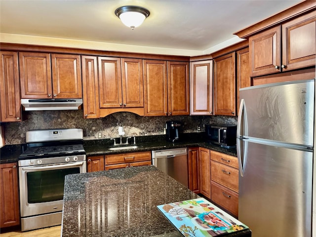 kitchen featuring tasteful backsplash, appliances with stainless steel finishes, sink, and dark stone countertops