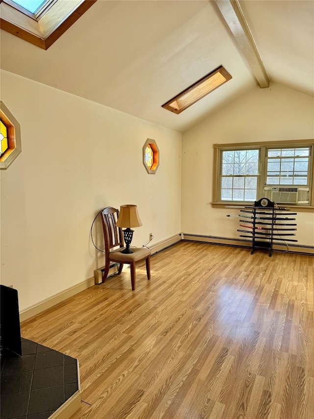 unfurnished room with cooling unit, a baseboard heating unit, lofted ceiling with skylight, and light hardwood / wood-style floors