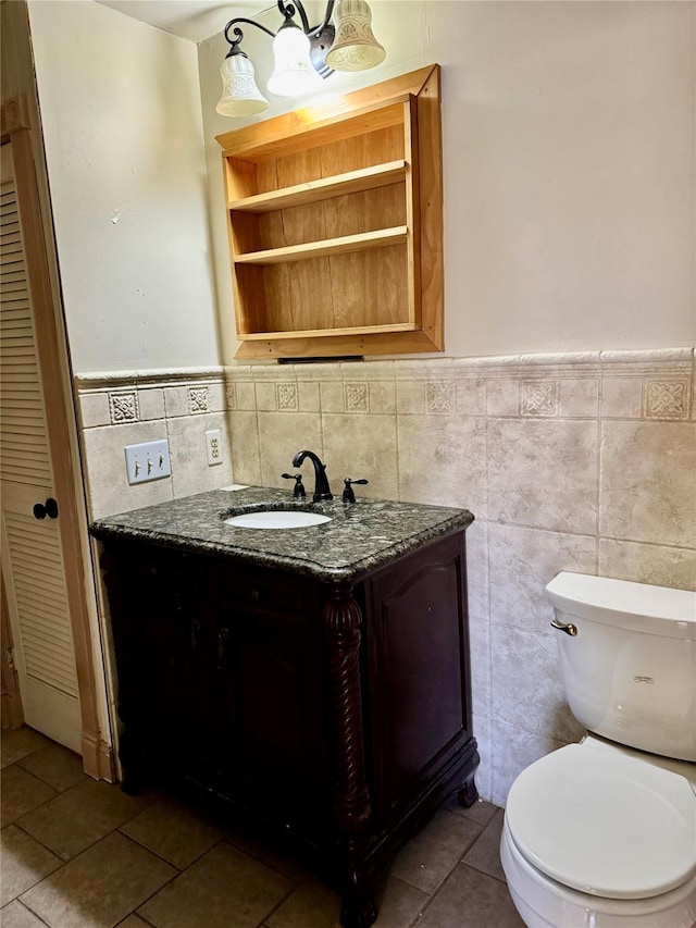 bathroom featuring vanity, tile patterned flooring, tile walls, and toilet