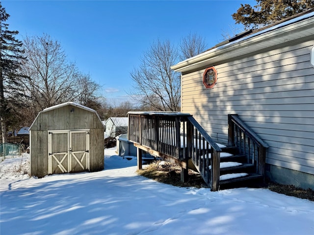 snow covered deck with a shed