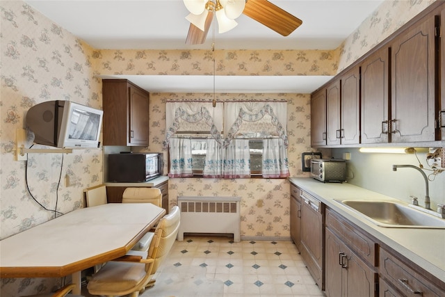 kitchen with sink, ceiling fan, paneled dishwasher, and radiator