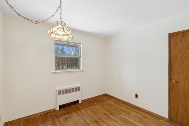 empty room with radiator and wood-type flooring