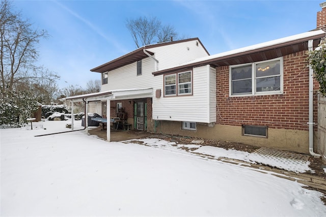 view of snow covered back of property