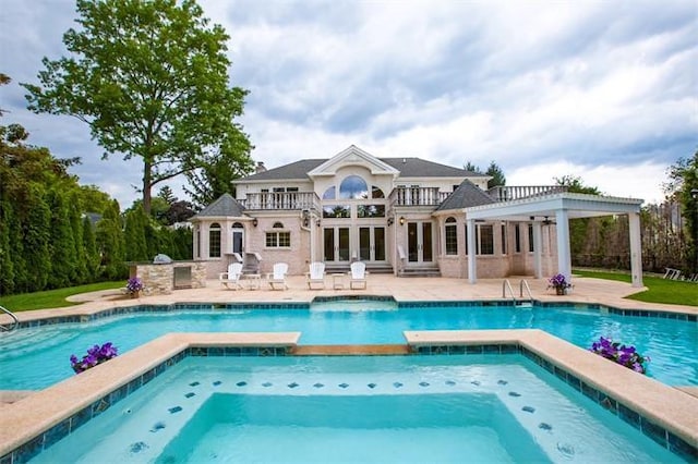 view of swimming pool featuring an in ground hot tub, a patio, and an outdoor kitchen