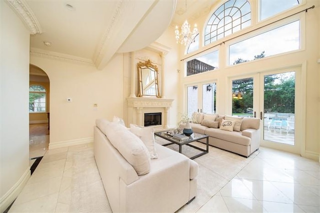 living room with a notable chandelier, french doors, crown molding, and light tile patterned floors