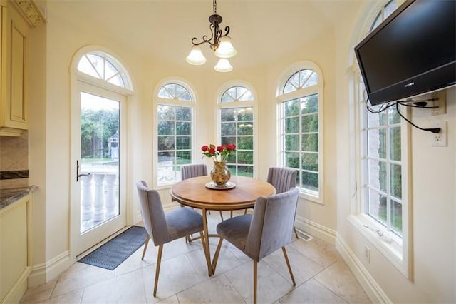 tiled dining space with plenty of natural light and a chandelier