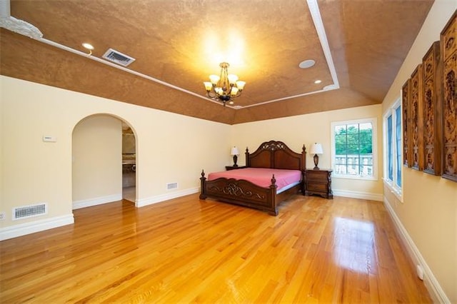 bedroom with wood-type flooring and a notable chandelier