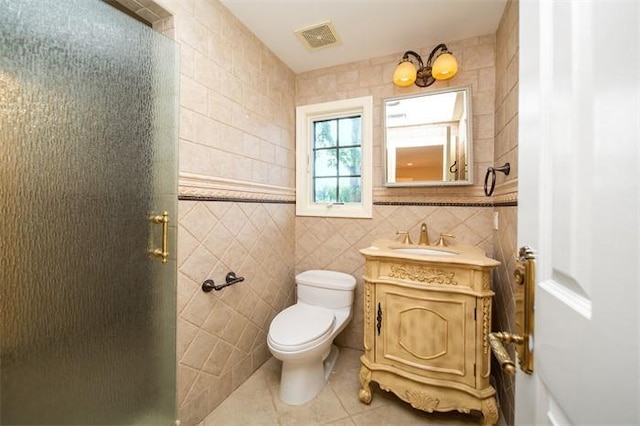 bathroom with tile patterned flooring, tile walls, toilet, walk in shower, and vanity