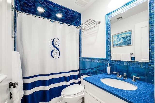 bathroom with vanity, toilet, curtained shower, and tile walls