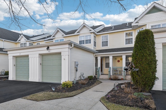 multi unit property featuring driveway, covered porch, and an attached garage