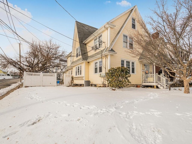 snow covered rear of property with central air condition unit