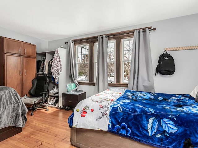 bedroom with wood-type flooring and multiple windows