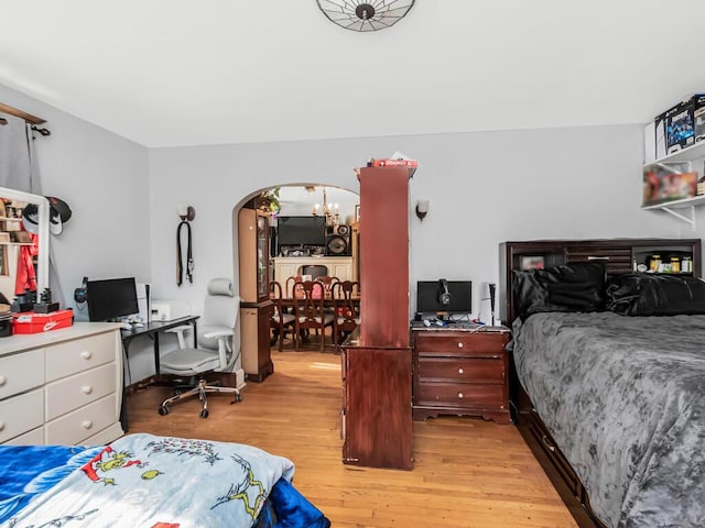 bedroom featuring a chandelier and light hardwood / wood-style flooring