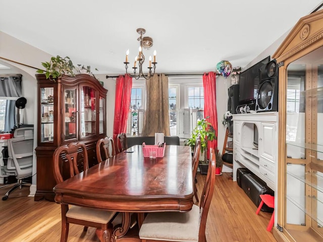 dining space featuring light hardwood / wood-style floors and a notable chandelier