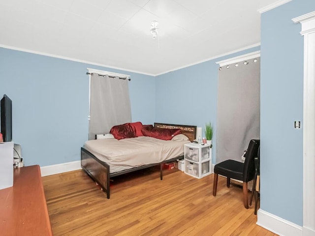 bedroom featuring wood-type flooring and crown molding