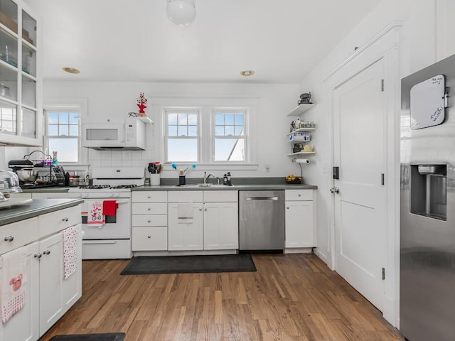 kitchen with white cabinets, stainless steel appliances, dark wood-type flooring, and plenty of natural light