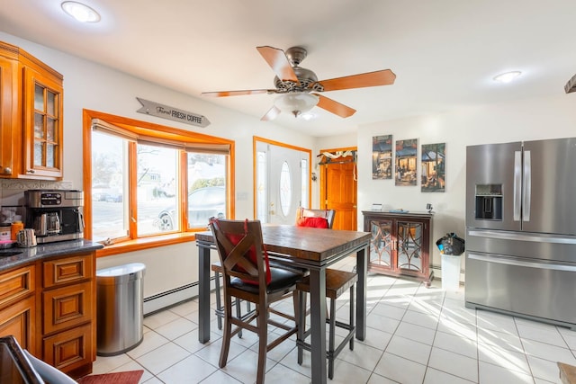 dining room featuring ceiling fan, a baseboard radiator, and light tile patterned floors