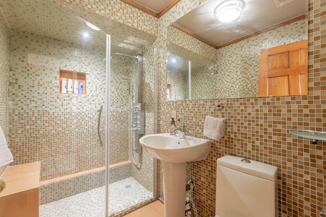 bathroom with a shower with shower door, toilet, tile walls, and crown molding