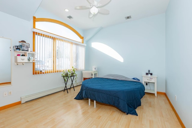 bedroom with ceiling fan, hardwood / wood-style floors, and a baseboard heating unit