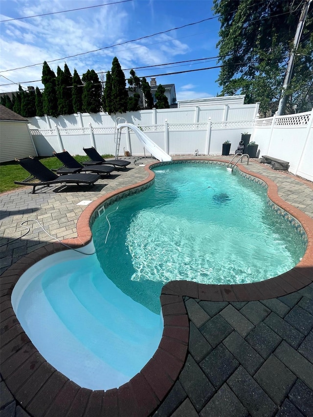 view of pool with a patio area and a water slide