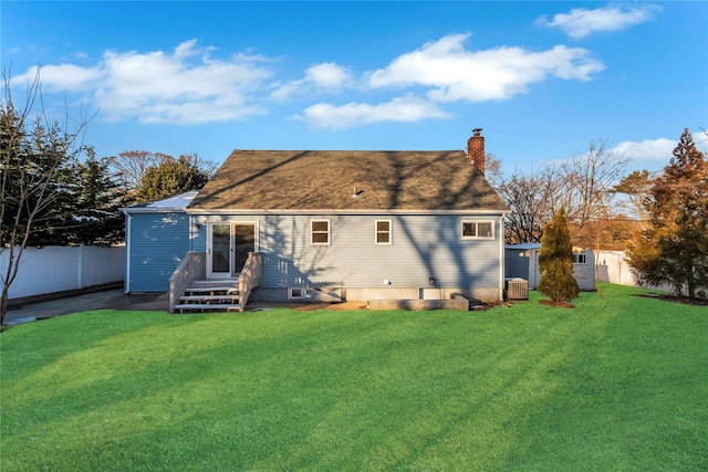 back of house with central air condition unit and a lawn