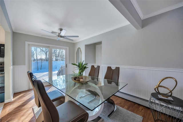 dining space featuring beam ceiling, baseboard heating, hardwood / wood-style floors, and crown molding