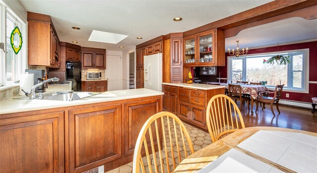 94 S Quaker Hill Rd, Pawling, NY 12564 - kitchen featuring white refrigerator with ice dispenser, a chandelier, glass insert cabinets, brown cabinetry, and stainless steel microwave