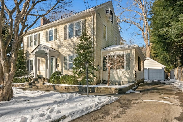 colonial inspired home featuring an outbuilding and a garage