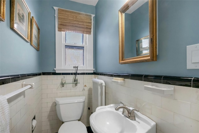 bathroom with sink, radiator heating unit, and toilet