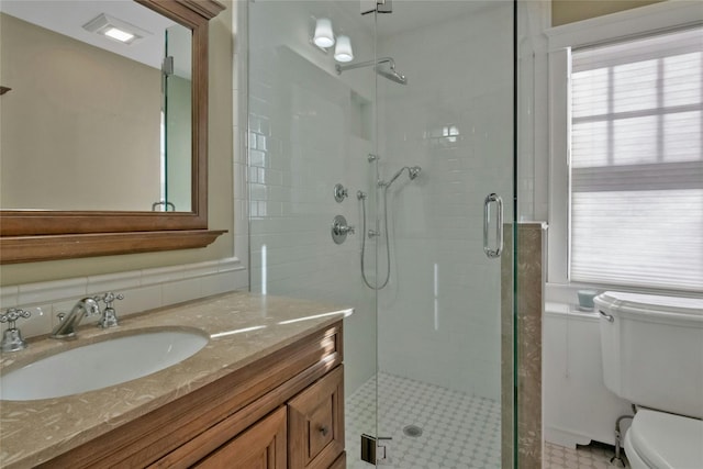 bathroom with an enclosed shower, vanity, and toilet